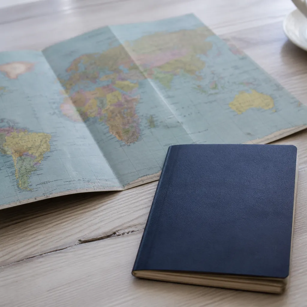 Documents de voyage et carte du monde posés sur une table, formalités de rapatriement